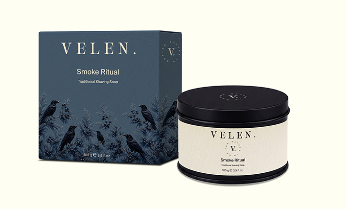 Packaging cosmétique éco-responsable Smoke Ritual de la marque VELEN. comprenant un savon à barbe premium et un étui illustré inspiré du cèdre et du corbeau