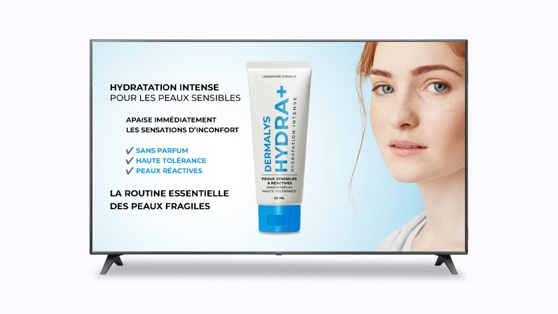 Écran TV diffusant une publicité digitale pour une crème hydratante Dermalys Hydra+ destinée aux peaux sensibles, présentée comme une PLV digitale en pharmacie avec visuel produit et modèle féminin.