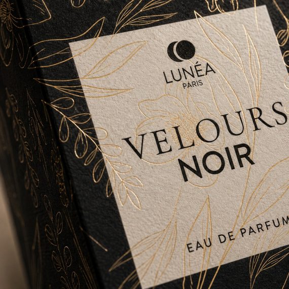 Macro du coffret Velours Noir mettant en valeur la dorure à chaud, le papier texturé et les finitions premium d'un packaging de parfum de luxe.