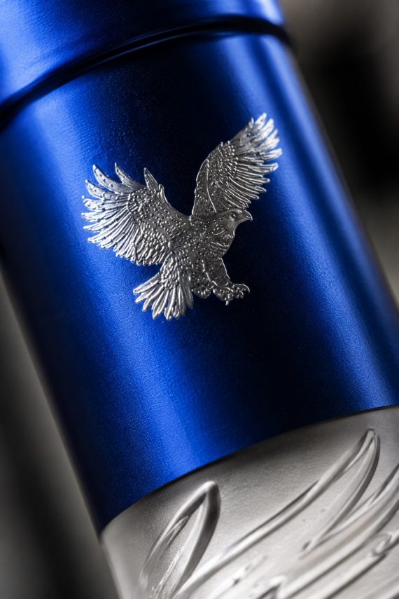 Macro de la capsule bleu métallisé de la bouteille de vodka Altai, mettant en valeur l'embossage de l'aigle et les finitions premium du packaging.