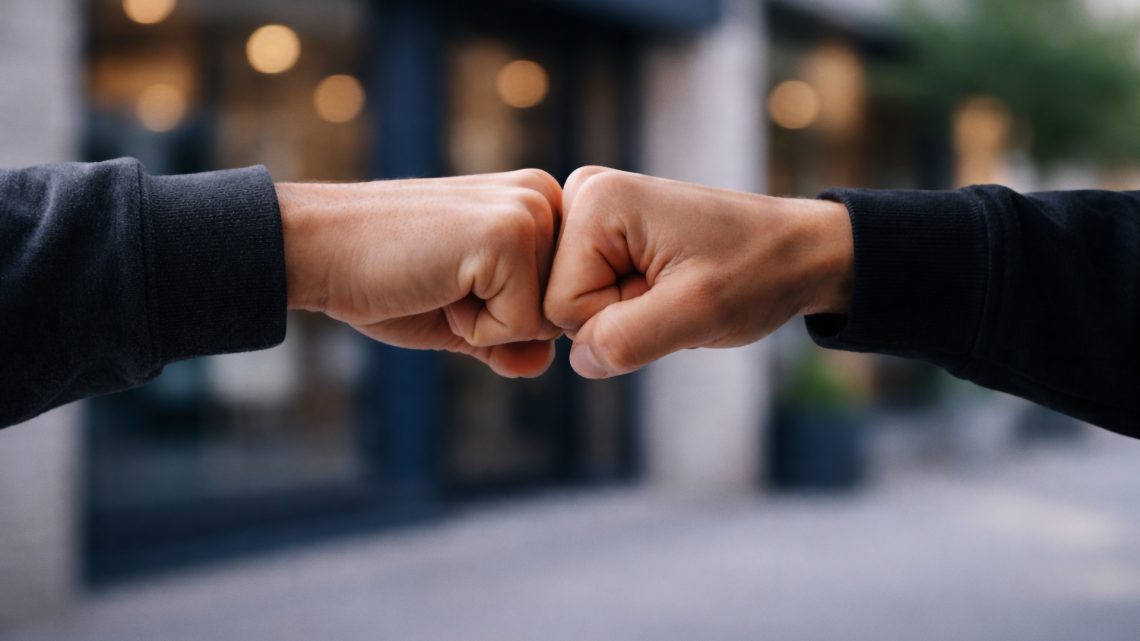 Geste de collaboration entre deux personnes illustrant un accompagnement visuel et une direction artistique sur mesure